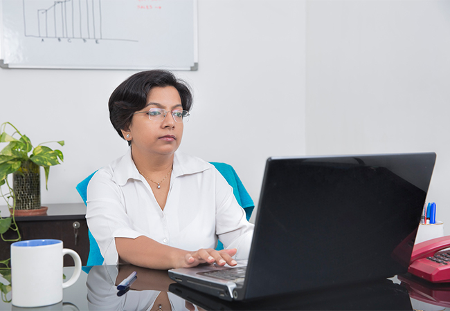 Business woman working on a laptop in an office.