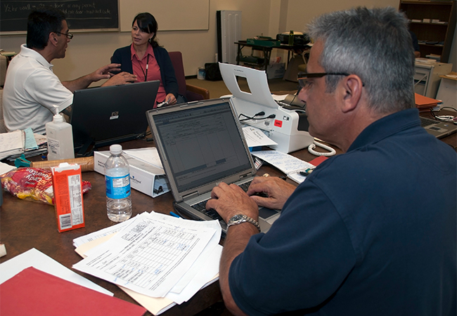 A FEMA Public Assistance specialist working on a computer.
