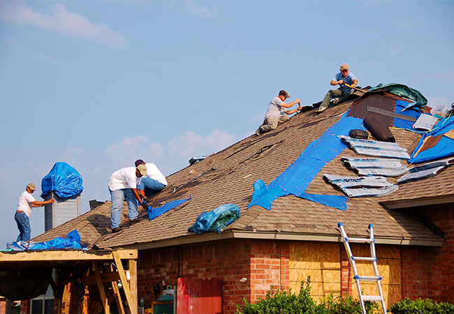 Roofers work to repair a home damaged in a tornado in Moore, Oklahoma.