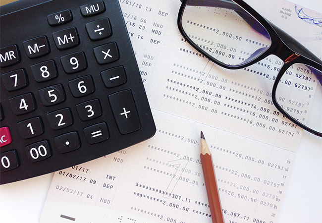 Pencil, calculator, eyeglasses and financial statement.