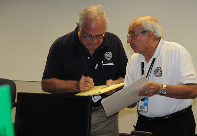A FEMA Public Assistance Project Officer confers with a state Lead Public Assistance Officer