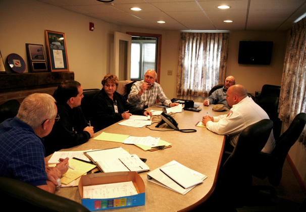 Several people at a conference table at a Recovery Scoping Meeting.