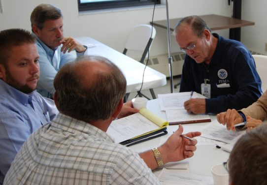 People sitting around a table at a Public Assistance scoping meeting.