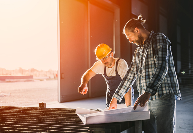 Construction workers checking blue print