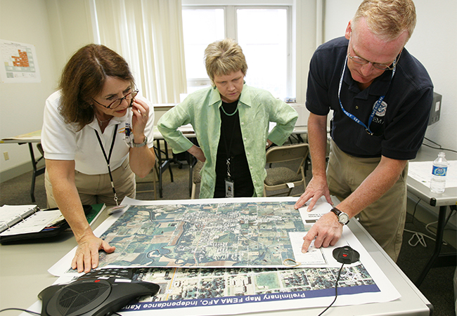 FEMA officials examine satellite imagery of a damaged area in Kansas.