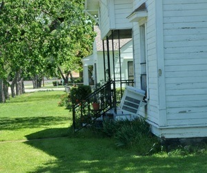 Photograph of house with portable air conditioner hanging out of the window