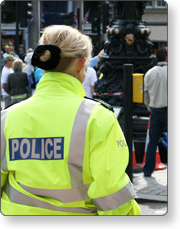 The back of a police officer wearing a green police jacket