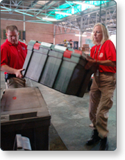 Emergency managers, a man and woman, placing trunk on table