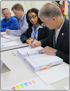 Image of individuals reviewing agreements.