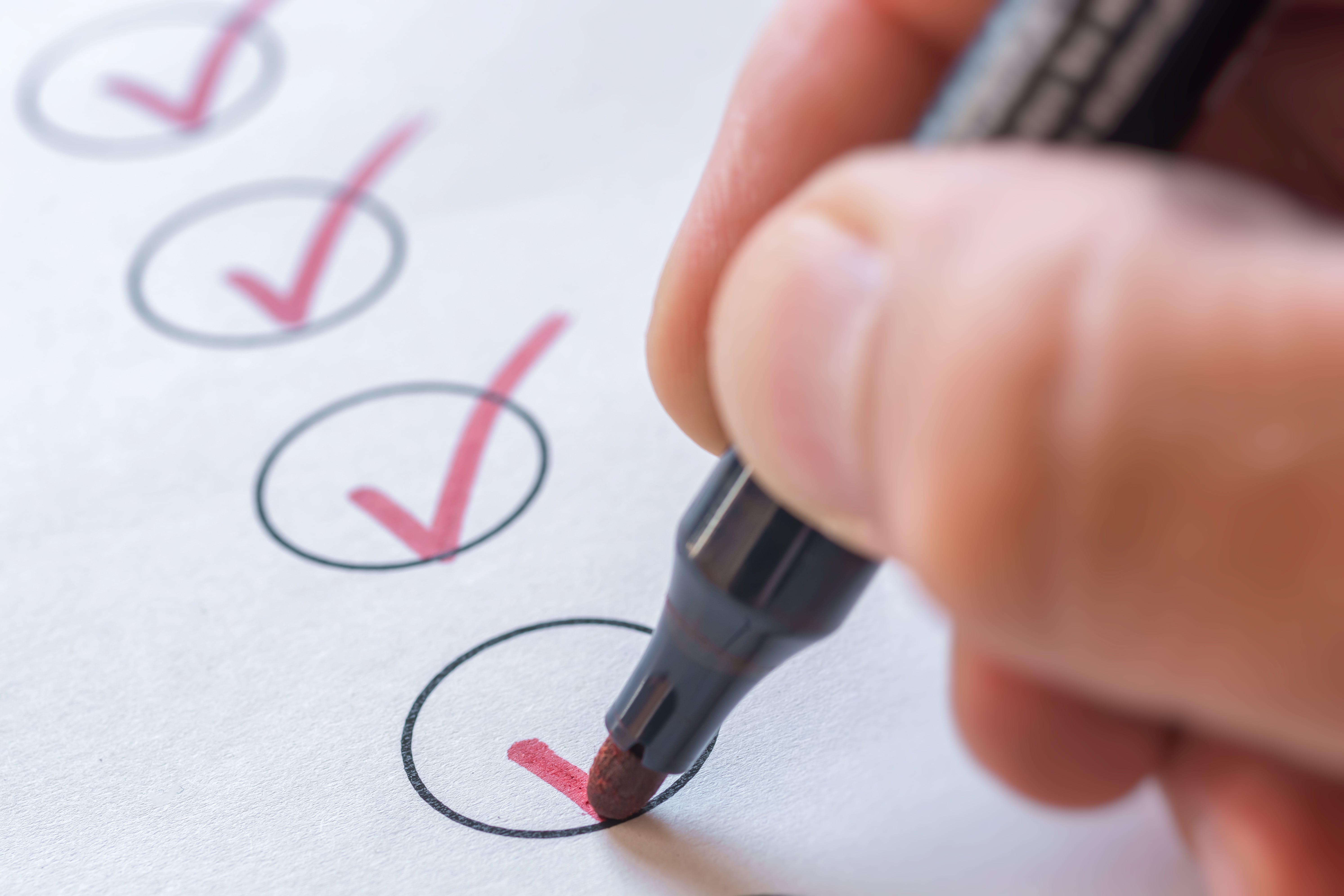 Hand with red marker, red checkmark
