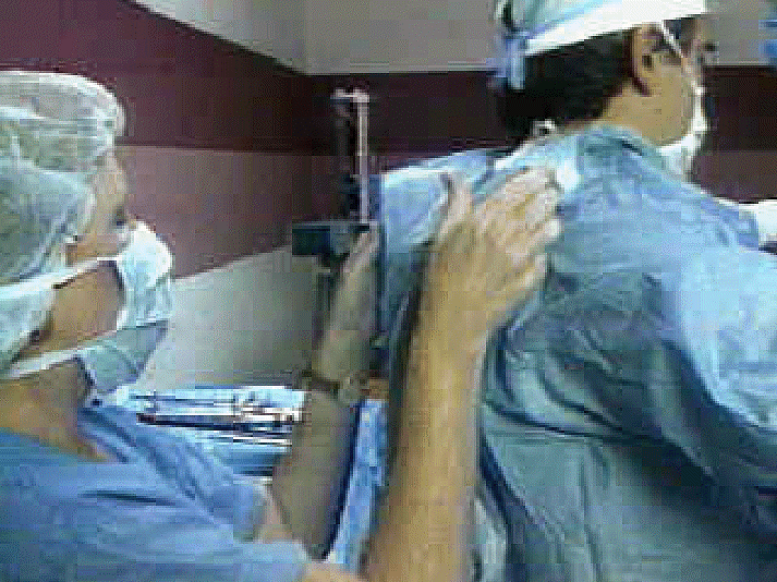 Nurse assisting doctor into gown