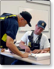 Two responders reviewing documents on a table.