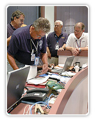 Incident Commander and responders standing behind a desk with laptops