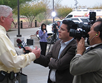 News reporter with cameraman interviewing a man