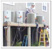 Contractor installing air-conditioner units on a platform