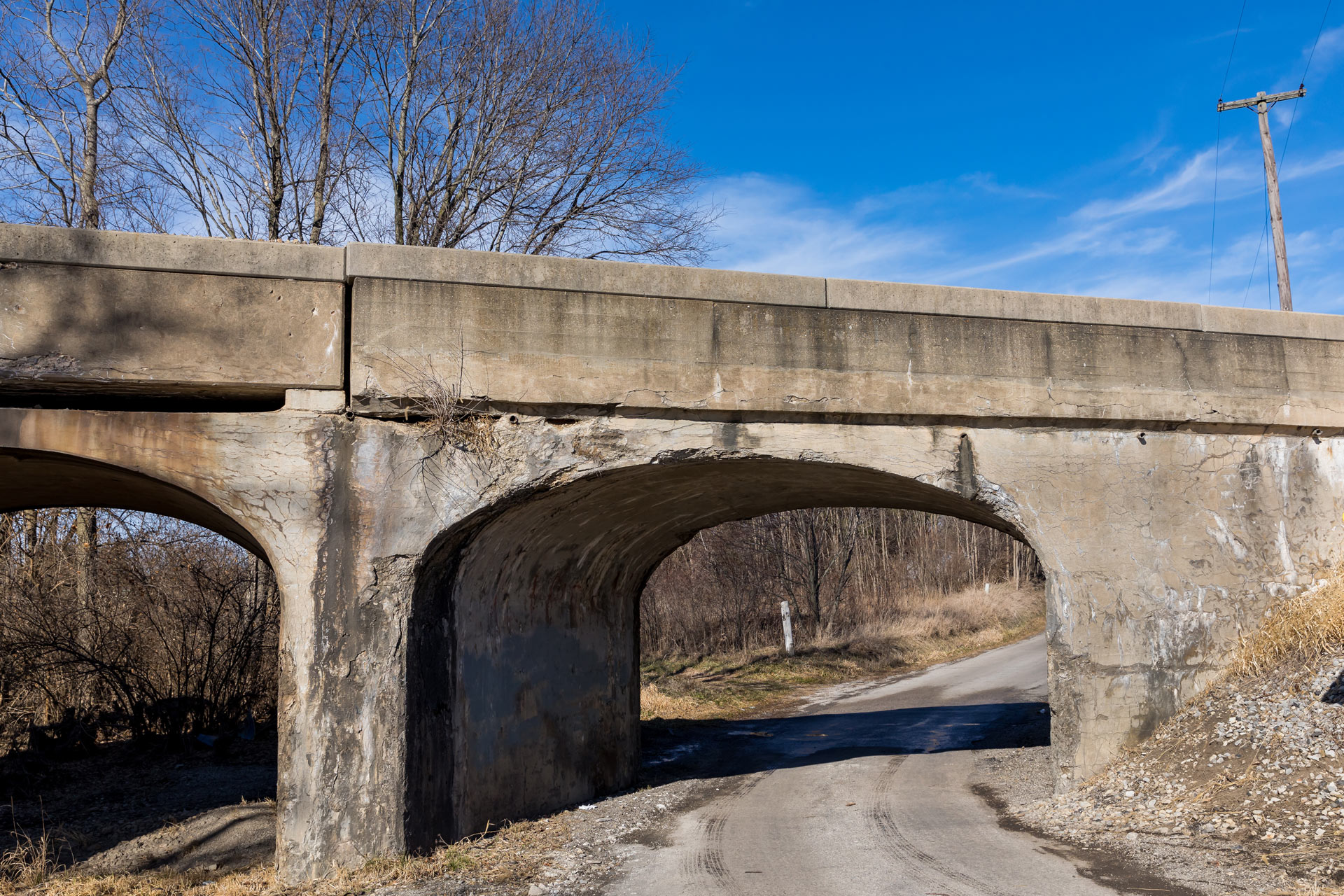 old railroad bridge with crumbling, cracking concrete.