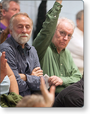 A man raising his hand at a community meeting