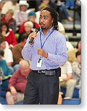 Person addressing community members at a public meeting