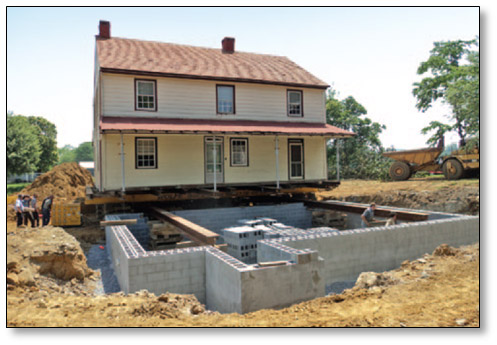 picture of a cement block foundation with a house ready to relocated.