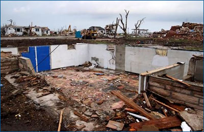 Photo of a damaged home with the basement exposed