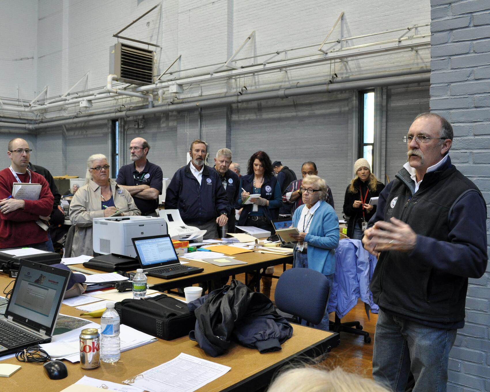 A Federal Coordinating Officer addresses FEMA staff at an operating facility to share information between FEMA and State agencies as part of recovery operations.