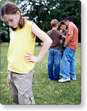 Girl looking sad with group of boys in background
