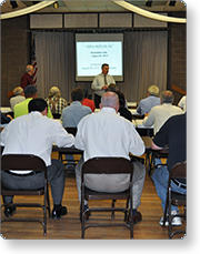 Group of people sitting in a room watching a presentation.