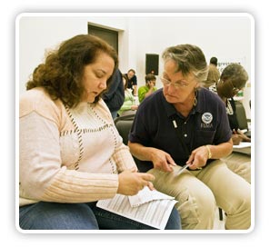 Photo of a FEMA individual assistance employee helping an applicant fill out a form