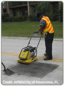 road crew workers smoothing a patched road