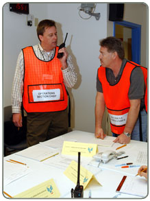 Image of students playing roles in Simulation Room.  One person is using a walkie talkie.