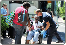 EMTs assisting elderly patient into wheelchair