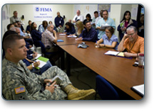 FEMA responders and military partners sit around a conference table