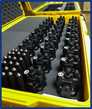 Photograph of two yellow ruggedized storage cases, each containing multiple portable radios.