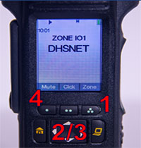 Close-up photograph of the front panel of a portable radio (Motorola APX model) showing a display screen with buttons underneath. The radio screen shot contains the time, battery strength indicator, zone name, channel name, and three menu items across the bottom. There is a number 1 below the "Zone" menu item on the screen, numbers 2 and 3 above the arrow buttons on the front panel, and a number 4 next to the left "soft button" on the front panel below the radio display screen. The radio display contains the following text: the time of 10:01 in the upper left corner, Zone IO1 in the center with DHSNET directly underneath representing the Zone and Channel Name. Three menu items across the bottom read Mute, Clck, Zone from left to right.