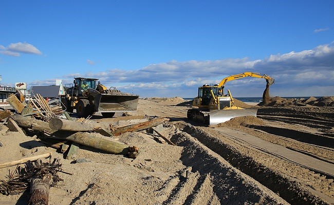 Heavy machinery is used to assist in the recovery process of debris removal and dune replenishment along this coastline.