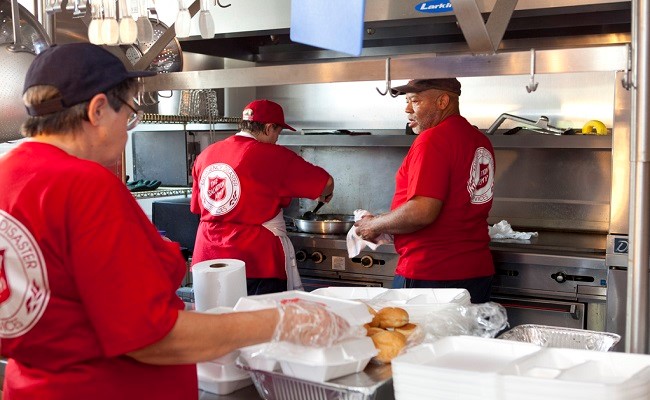 Salvation Army volunteers prepare meals for residents displaced to shelters.