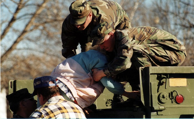 National Guardsmen help an elderly lady into a truck as town is evacuated.