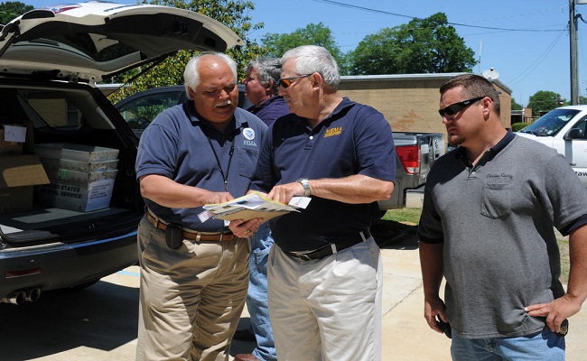 FEMA Site Inspector, Disaster Recovery Center State Manager and County Management Director discuss post site inspection tasks.