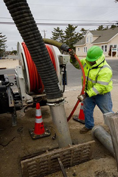 Construction worker filters sand off sewers to prevent rainwater from clogging the sewers and flooding the streets.