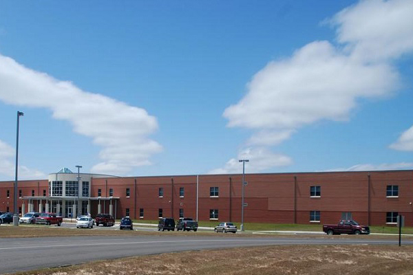 A school building, parking lot, and lawn