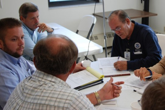 A group of people talking at a table in a meeting.