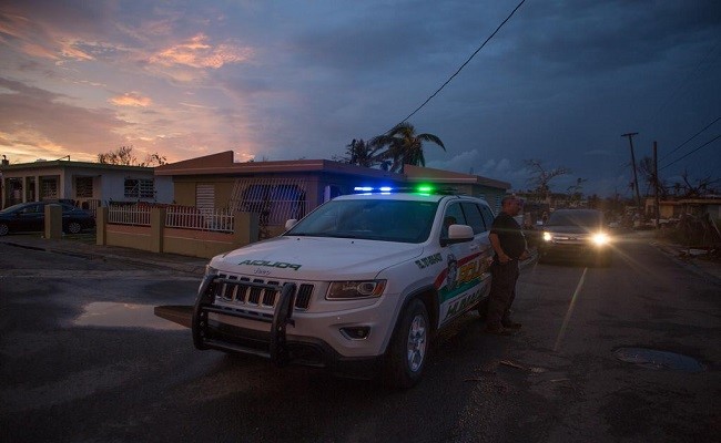 Police provide protection to properties in the Santa Maria neighborhood near Humacao, Puerto Rico.