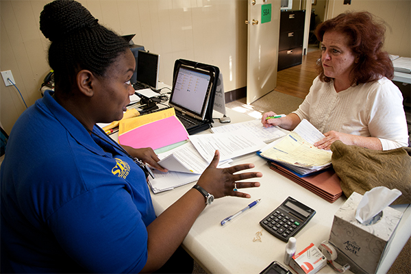 A Small Business Administration counselor reviews paperwork for a survivor.