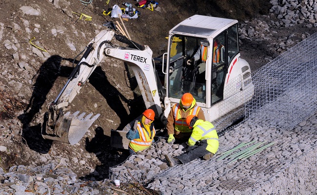 FEMA conducts stabilization efforts by placing gabion walls of stone along a road to prevent washout.