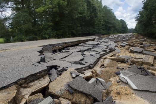 A severely damaged highway road.