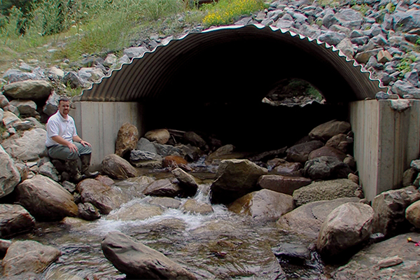 U.S. Forest Service Civil Engineer sits outside a culvert on a tributary running through the Moosalamoo National Recreation Area in Arlington, Vermont.