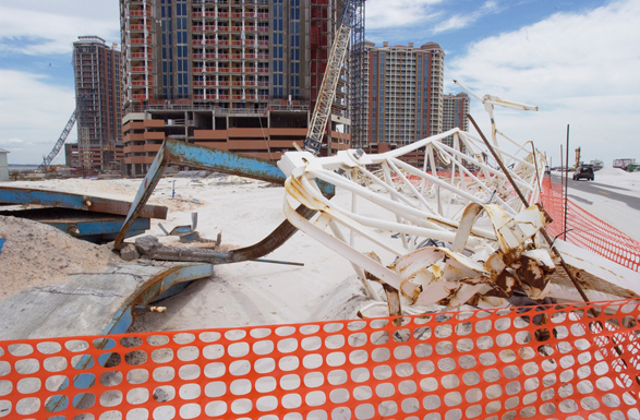 Cranes work to repair high rise buildings damaged in Hurricane Ivan and Hurricane Dennis. Orange netting fences off debris.