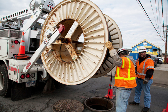 Contractors run new telephone cables to replace equipment ruined by Hurricane Sandy.