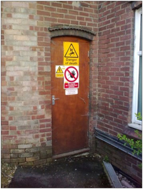 An exterior door with multiple hazard signs, including danger of death.