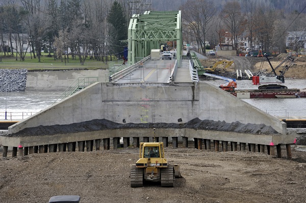 Construction equipment at work rebuilding the approach to a bridge and lock of the New York State canal system that was destroyed by flooding from Hurricane Irene.